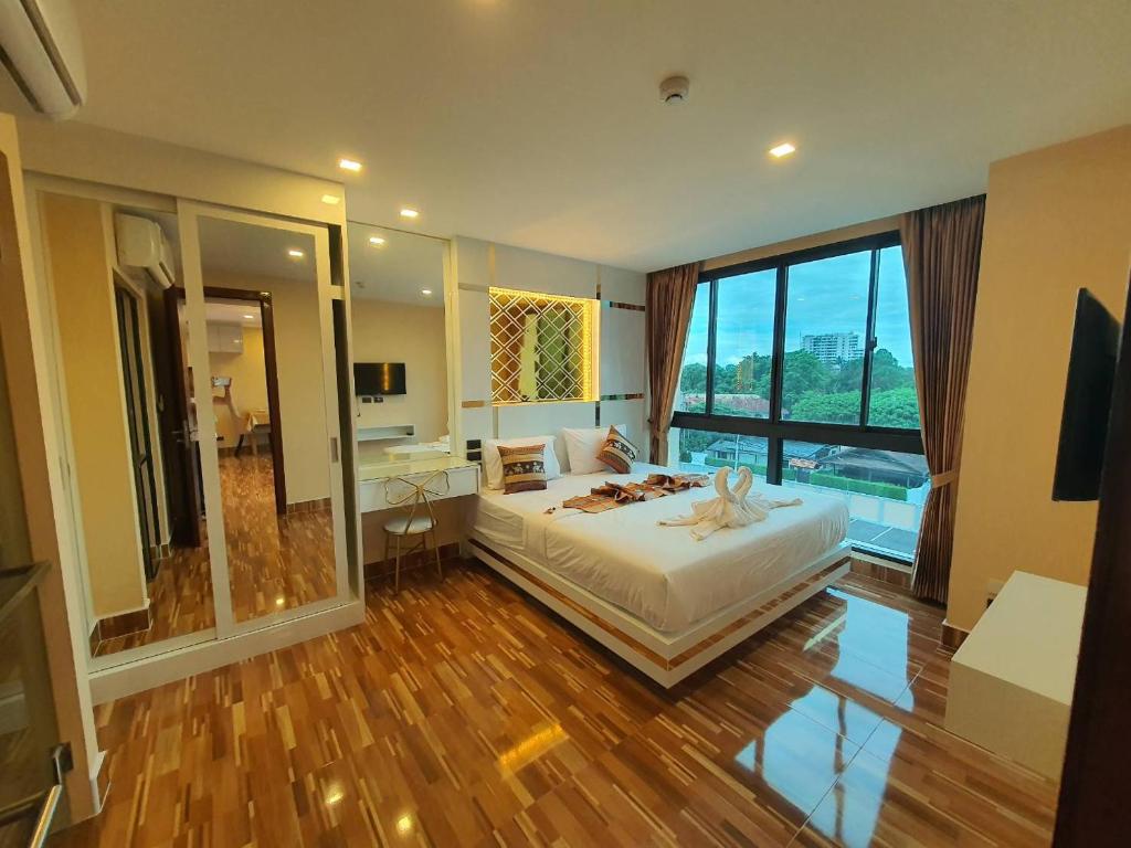 a hotel room with a bed and a large window at Doi Sutep Hill in Chiang Mai