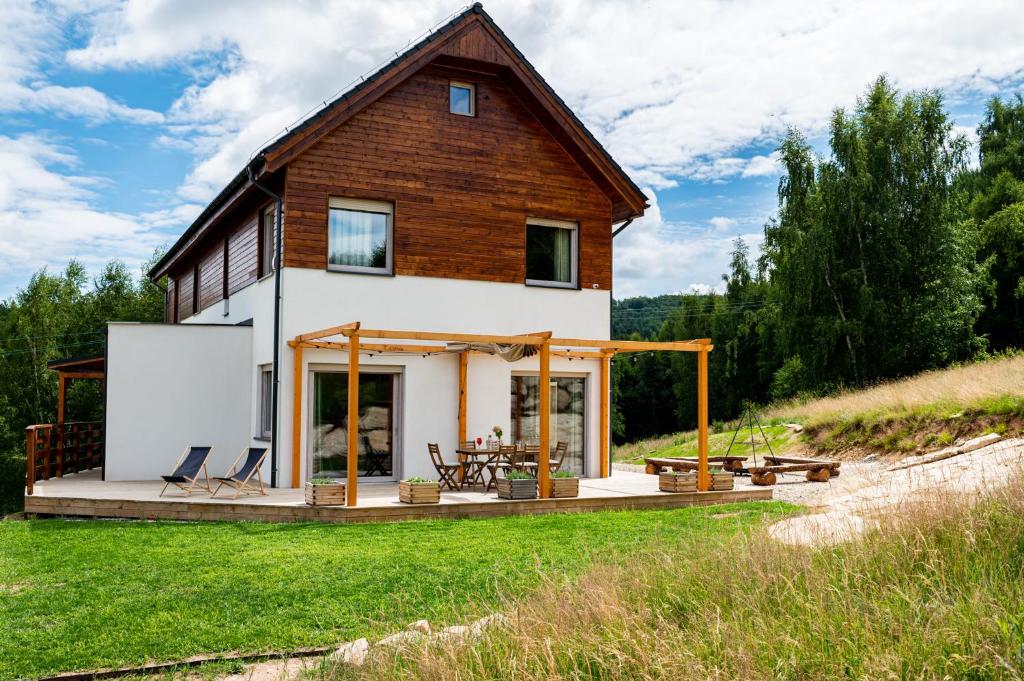 a house on a hill with a deck at MONTEZERA sauna i widok na góry in Piechowice