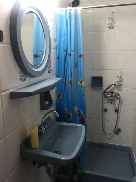 uma casa de banho com um lavatório e um chuveiro com um espelho. em Valerie's House em Poros