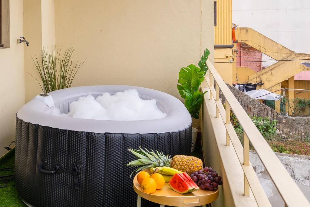 a hot tub on a balcony with fruit on a table at Trendy Bright Flats with Jacuzzi - 5 min Beach in Matosinhos