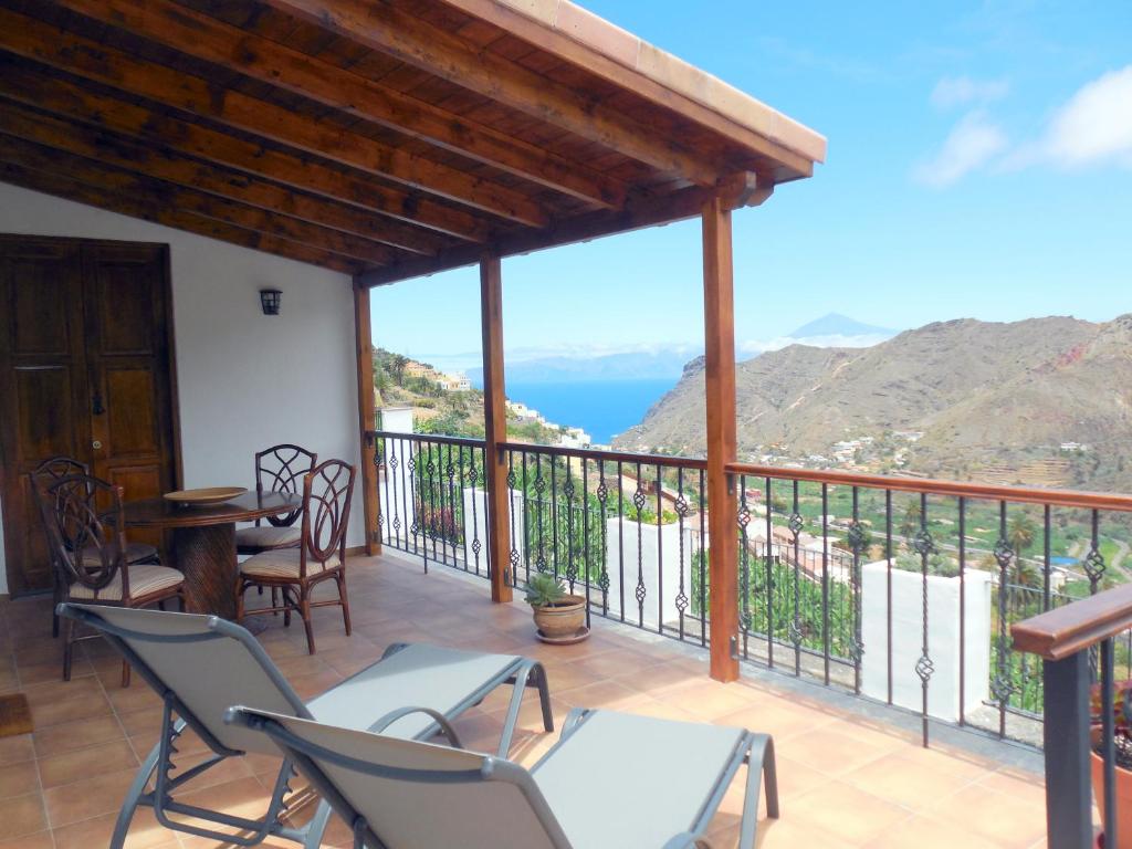 a balcony with chairs and a view of the ocean at Casa La Sabina Roja 1 - Casa con impresionantes vistas sobre Hermigua y el mar in Hermigua