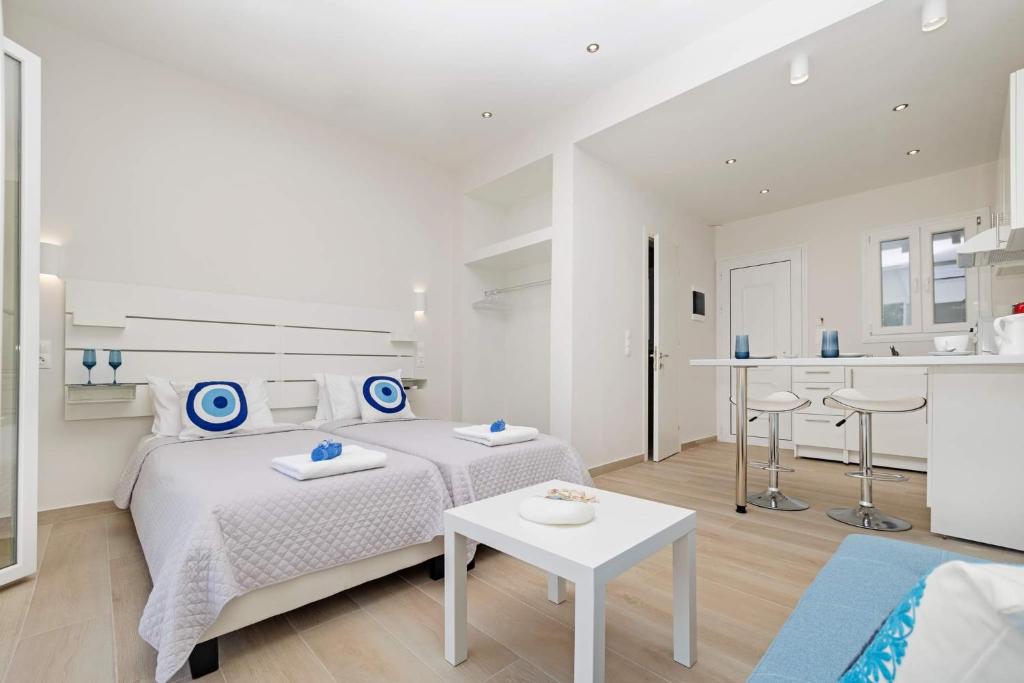 Dormitorio blanco con cama y mesa en E & G figareto apartments 5 en Kanoni