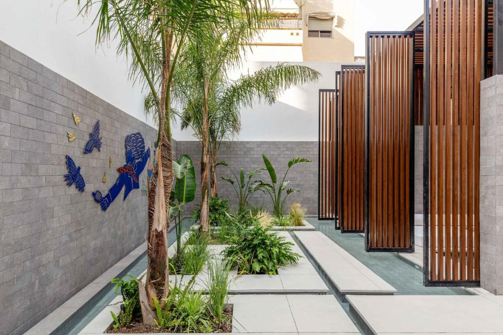 un patio con palmeras en un edificio en The Newel Psychiko en Athens