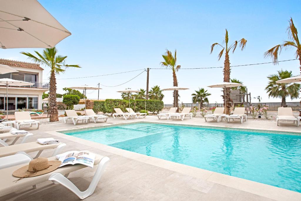 Una piscina con tumbonas y un resort. en Malgrat de Mar Beachfront Village, en Malgrat de Mar