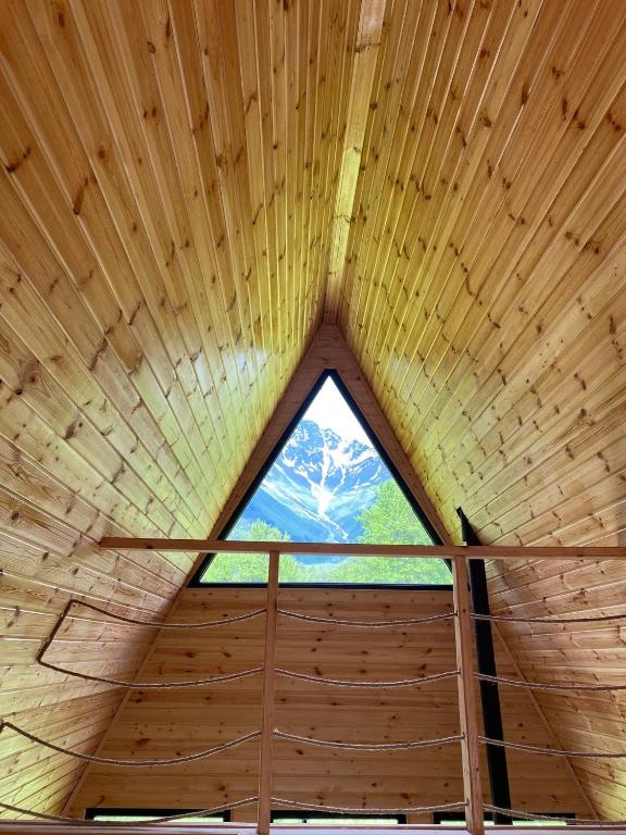 a large window in a wooden roof of a cabin at Labna Huts in Mestia