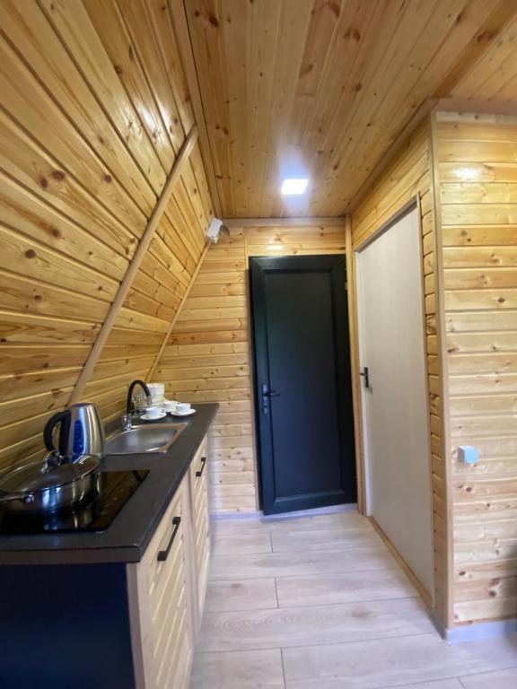 a kitchen in a log cabin with a black counter top at Labna Huts in Mestia