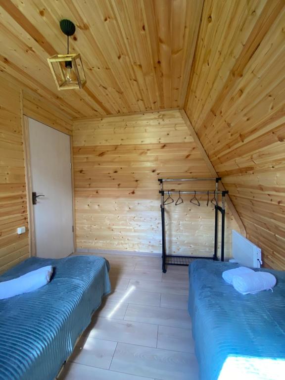 two beds in a room with a wooden ceiling at Labna Huts in Mestia