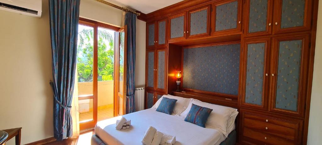 Villa Recanati في جيارديني ناكسوس: غرفة نوم بسرير ابيض ونافذة