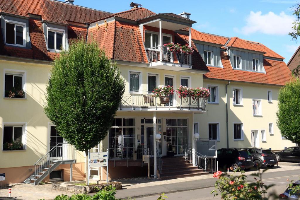 a large white building with flowers on the balconies at Hotel Alexa in Bad Mergentheim