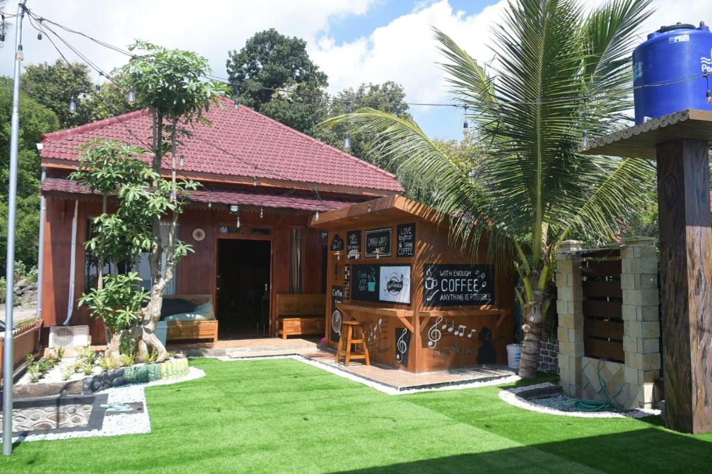 una casa con un bar y un patio verde en Omah Kayu Villa en Pasirputih