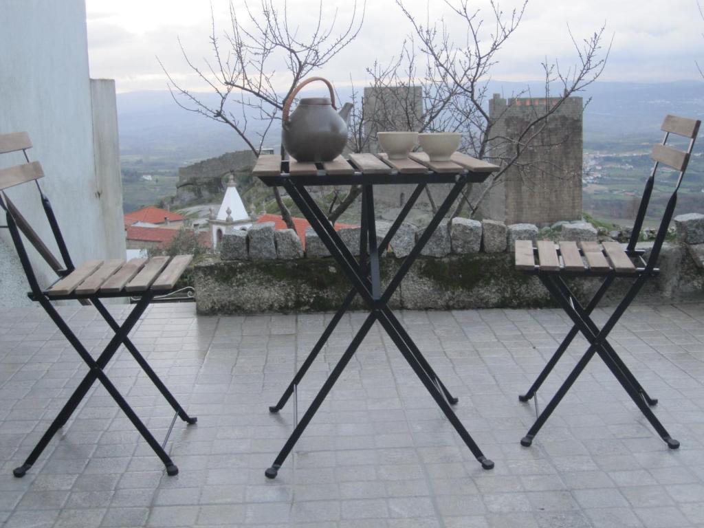 a table and two chairs with a tea kettle on it at Casa do Açor in Linhares