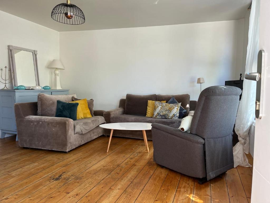 ein Wohnzimmer mit 2 Sofas und einem Tisch in der Unterkunft Le Loft, l'annexe in Lorient