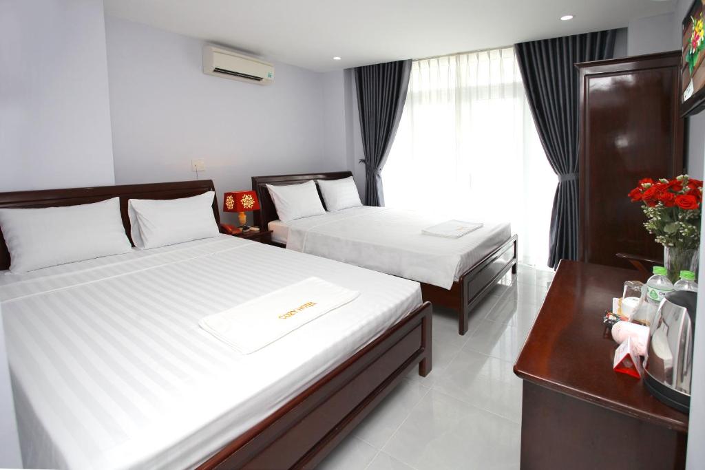 a hotel room with two beds and a window at Nhatrang Cozy Hotel in Nha Trang