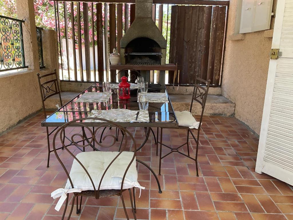 a table and chairs on a patio with an oven at MINI VILLA BORD DE MER in San-Nicolao