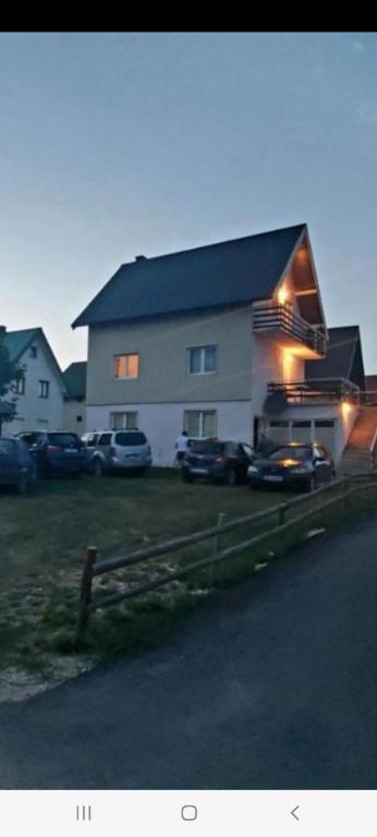 a large house with cars parked in front of it at Guesthouse Mijatovic in Žabljak