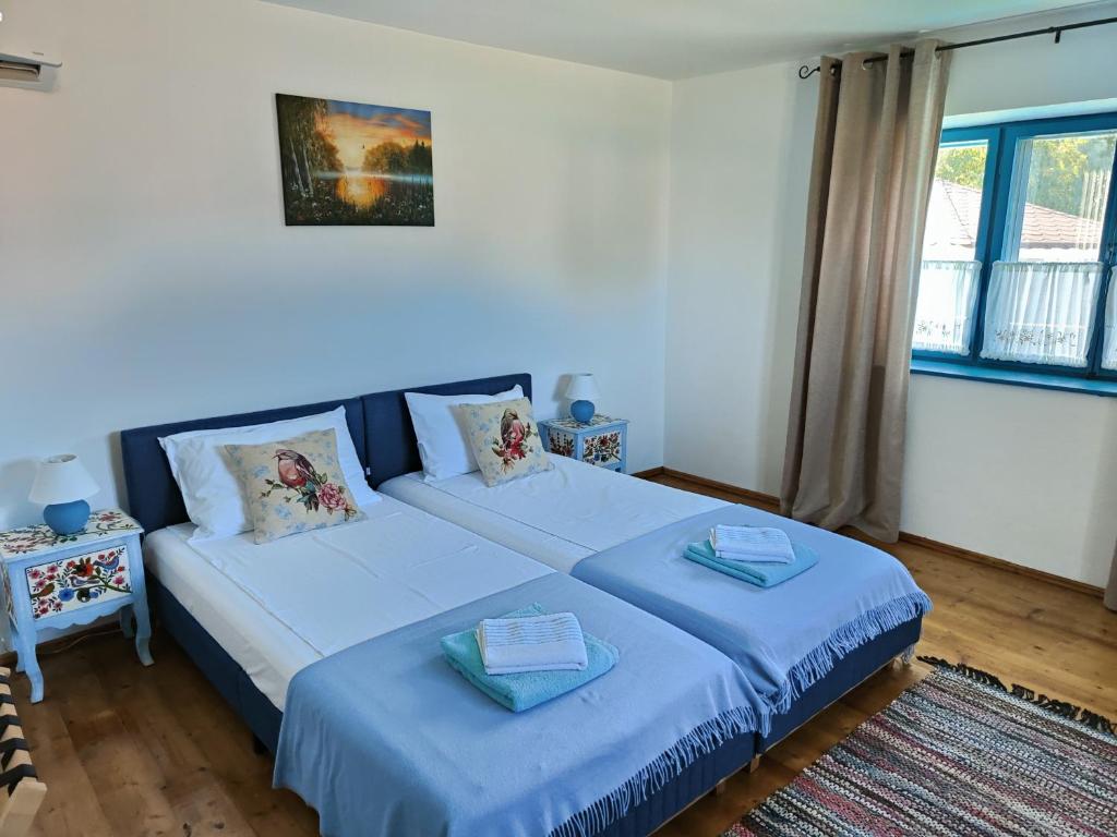 een slaapkamer met 2 bedden met blauwe lakens bij Gorgova Delta Village in Gorgova