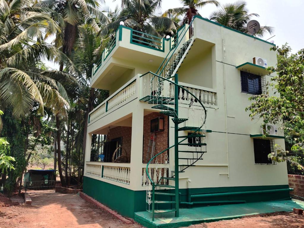a building with a spiral staircase in front of it at Rama Niwas Beach Home Stay in Pawas