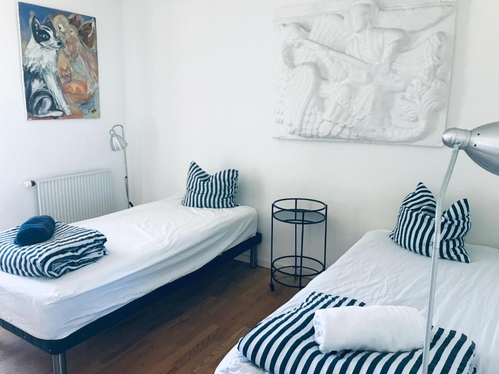 2 camas con almohadas de rayas azules y blancas en una habitación en Seaview and Swimming, en Hellerup