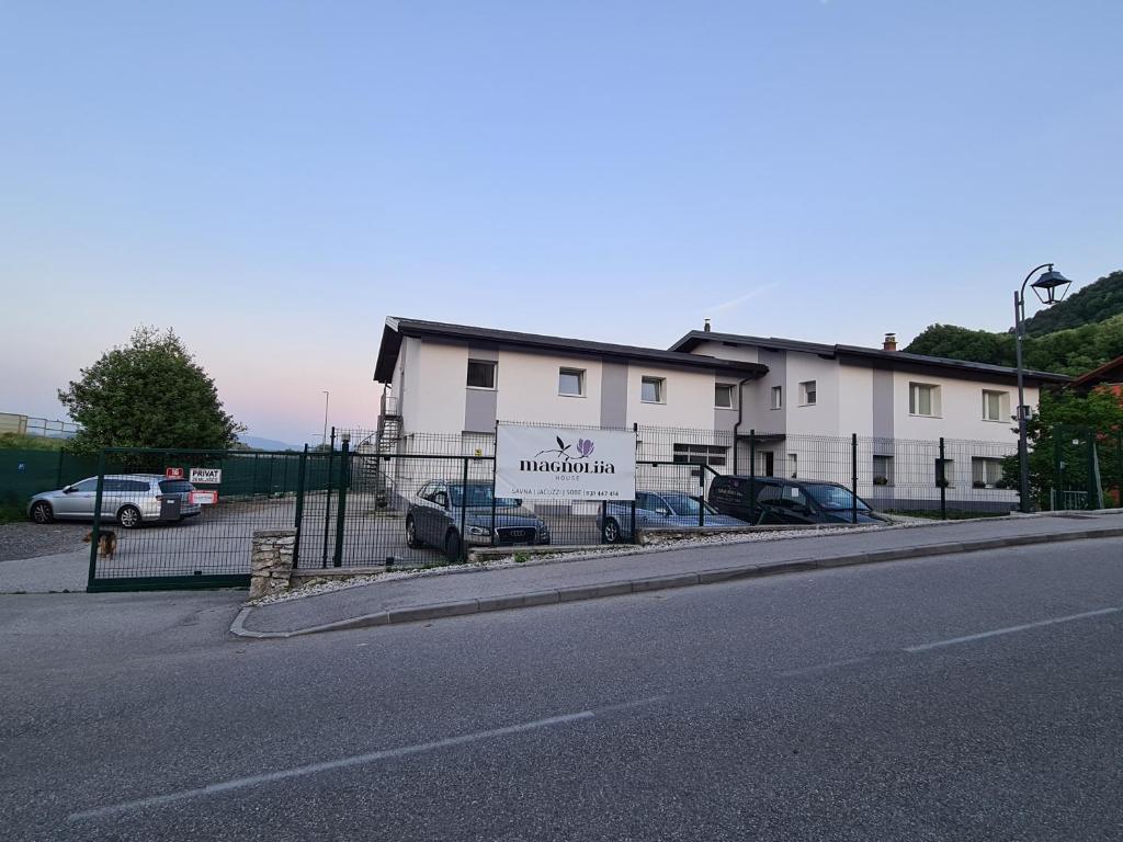 a white building with cars parked in a parking lot at MagnolijaHouse in Brežice