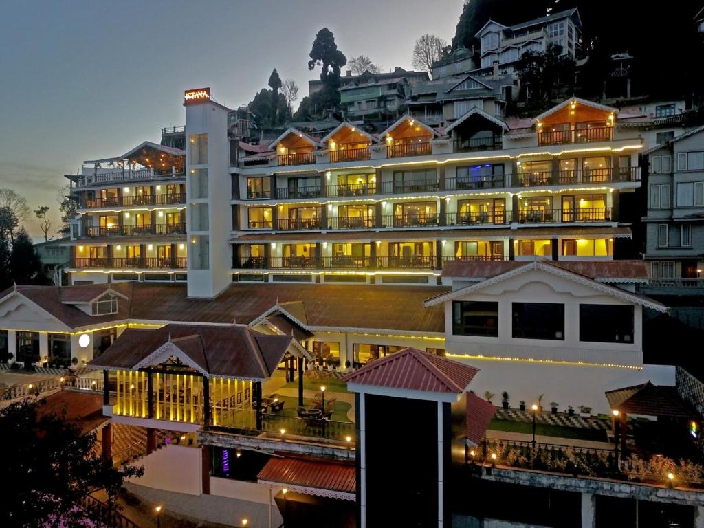 een groot gebouw met lichten aan voor het bij Istana Resort & Spa in Darjeeling