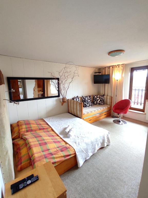 a bedroom with a bed and a red chair at Willa Aba in Tylicz