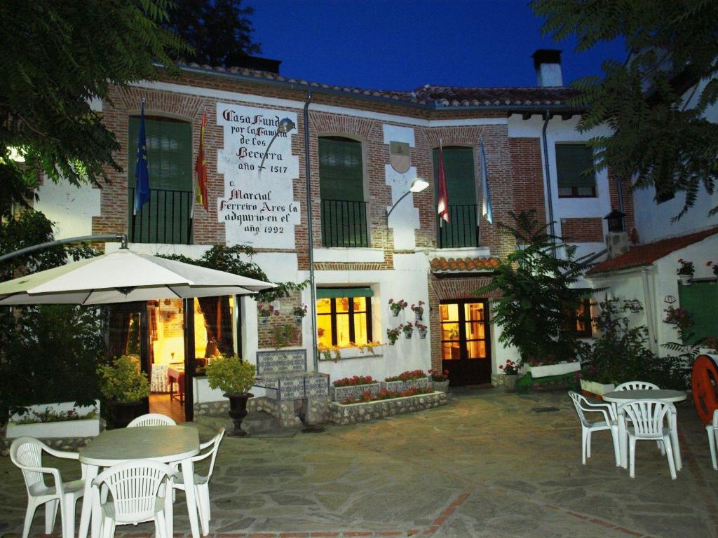 奧爾梅多的住宿－格蘭波薩達拉米思那達酒店，前面设有桌椅的建筑