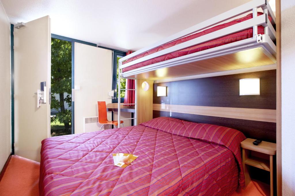 - une chambre avec des lits superposés et un couvre-lit violet dans l'établissement Premiere Classe Bourges, à Bourges