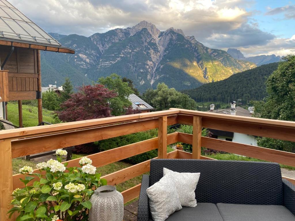 uma varanda com um sofá e vista para as montanhas em Casa Belvedere em Pieve di Cadore