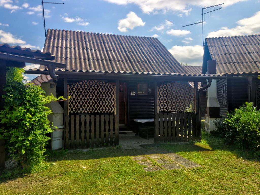 a house with a wooden gate in a yard at Chalet 68 Terme Čatež with Swimming tickets in Brežice