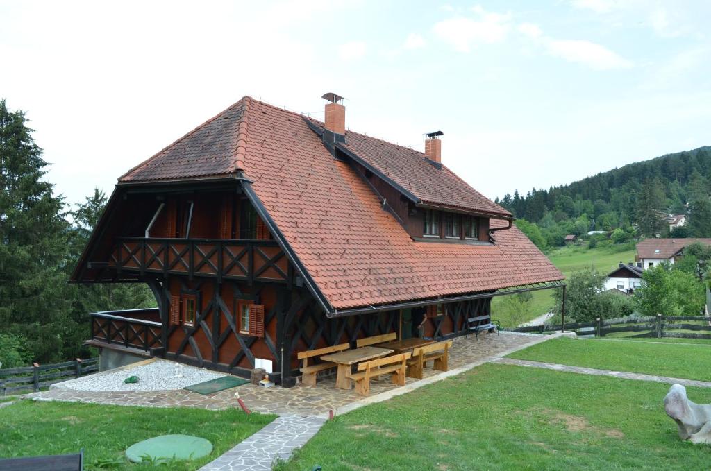 ein großes Holzgebäude mit rotem Dach in der Unterkunft Posestvo Brinje 
