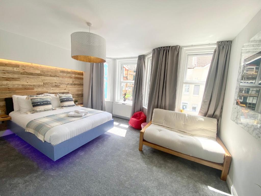 a bedroom with a bed and a chair in it at Coastline Retreats - Cloud9 Newly Renovated, Beautiful Ensuite Rooms Near Seafront in Town Centre, Netflix, SuperFast WiFi, Communal Kitchen in Bournemouth
