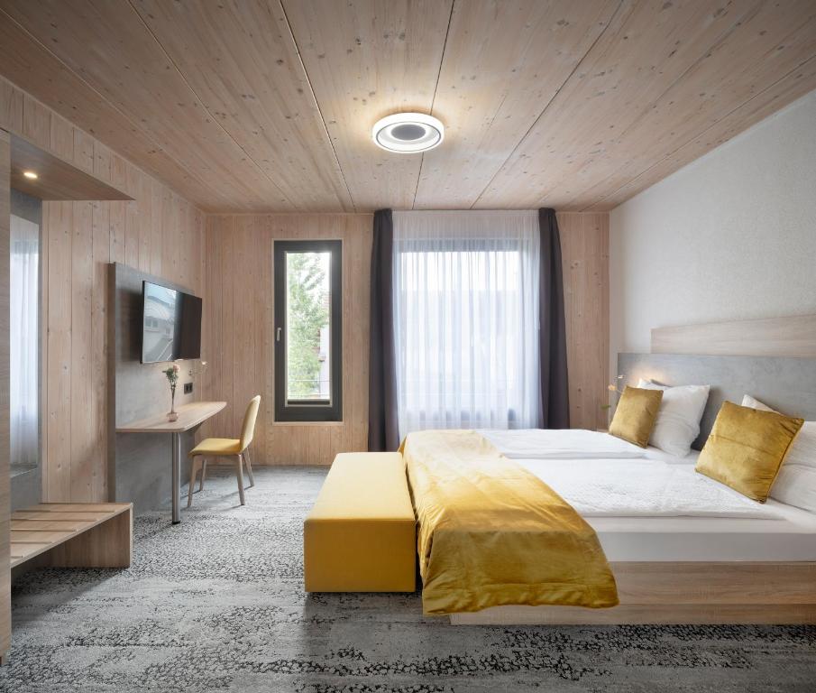 a bedroom with a bed and a desk and a television at Ferienwohnung im Vogelgesang W4 in Heuchelheim-Klingen
