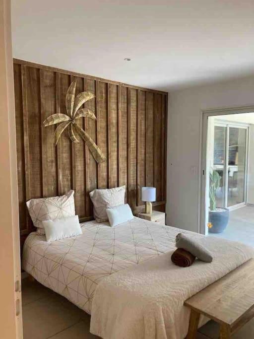 a bedroom with a large bed with a wooden wall at Maison entre bordeaux et le bassin d&#39;arcachon avec piscine et jaccuzi 2 a 6 pers in Saint-Jean-dʼIllac