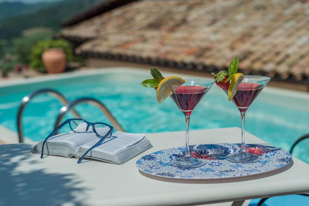zwei Martinis auf einem Tisch neben einem Pool in der Unterkunft Villa Doriana 6 in Acqualagna
