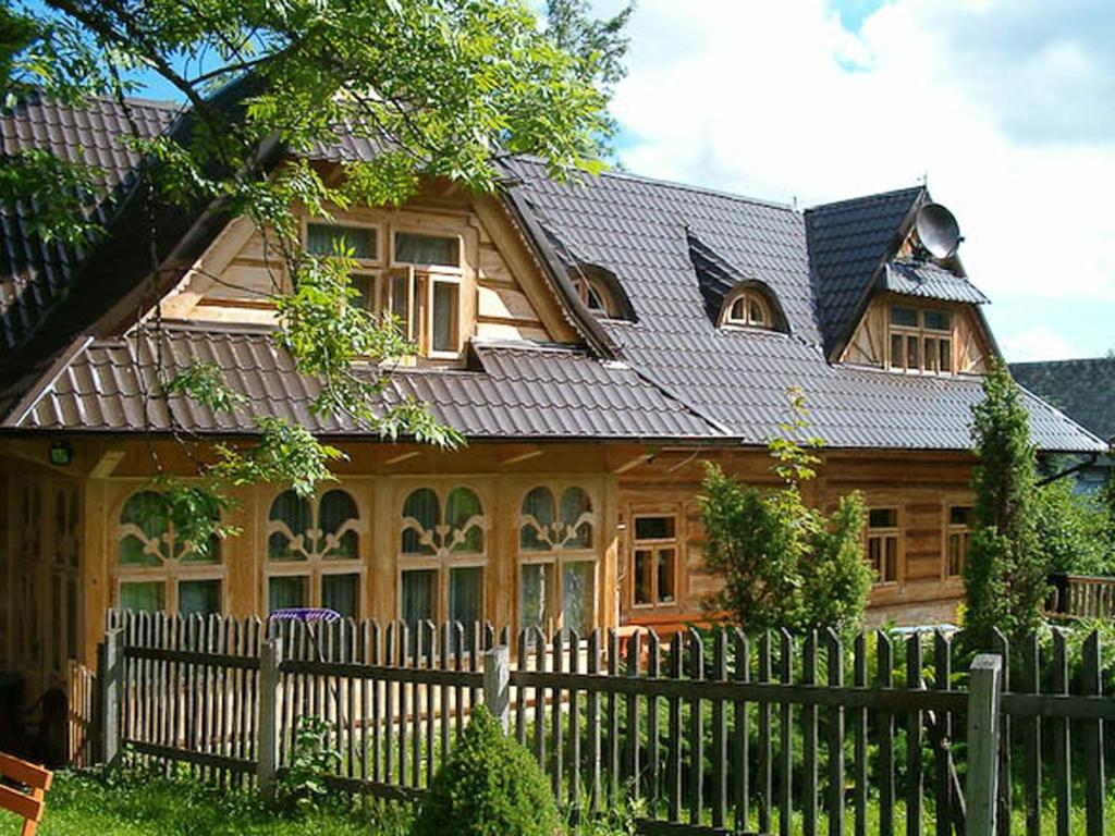 a wooden house with a fence in front of it at Willa u Krzeptowskich in Kościelisko