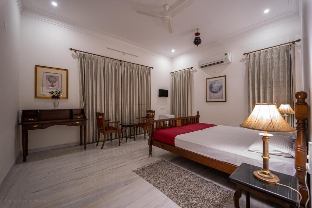 a bedroom with a bed and a table and a desk at Radhe Krishna Niwas in Udaipur