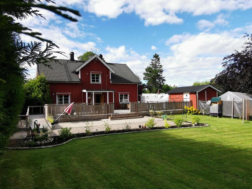 a red house with a garden in the yard at Yaberg Affären in Hyltebruk