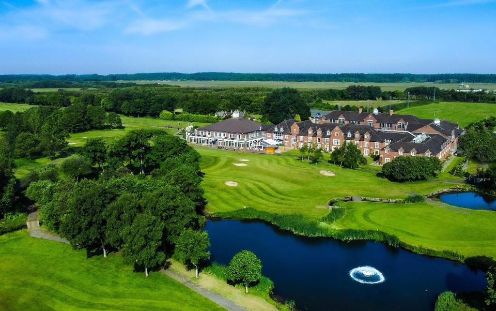 an aerial view of a mansion with a lake at Formby Hall Golf Resort & Spa in Southport