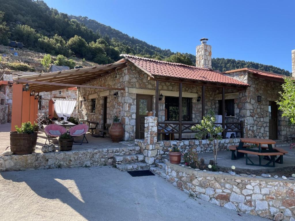 uma casa de pedra com uma mesa e um banco em Mike Omalos Houses em Omalos