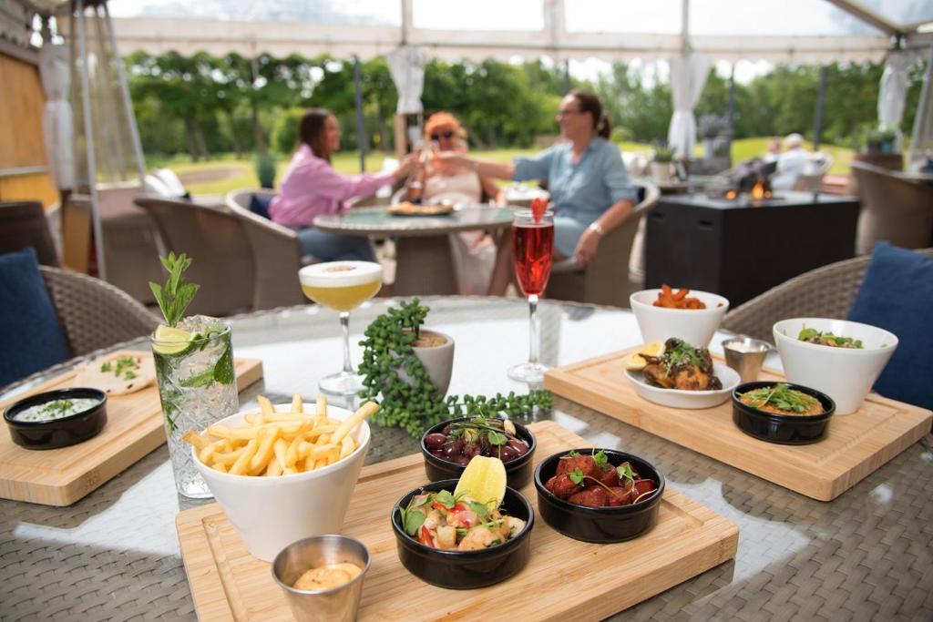 a table with food and drinks and people sitting at a table at Formby Hall Golf Resort & Spa in Southport