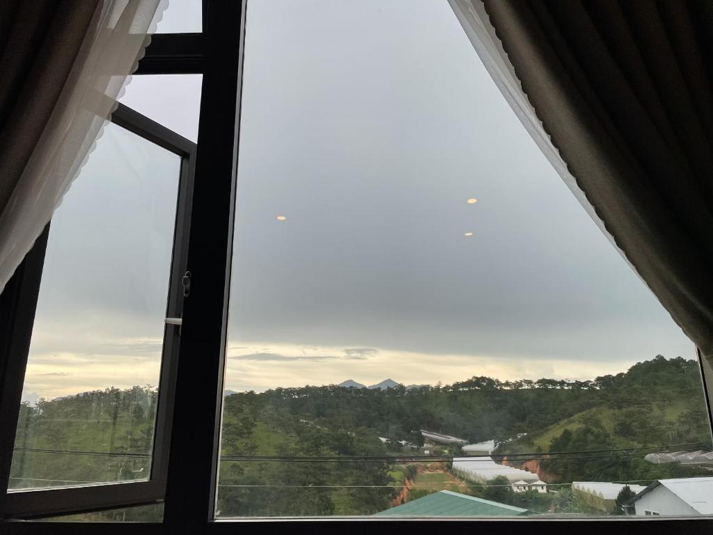 a window with a view of a mountain at Villa Délight House “Stay&Chill” in Da Lat
