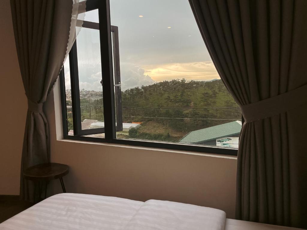 a bedroom with a window with a view of a mountain at Villa Délight House “Stay&Chill” in Da Lat