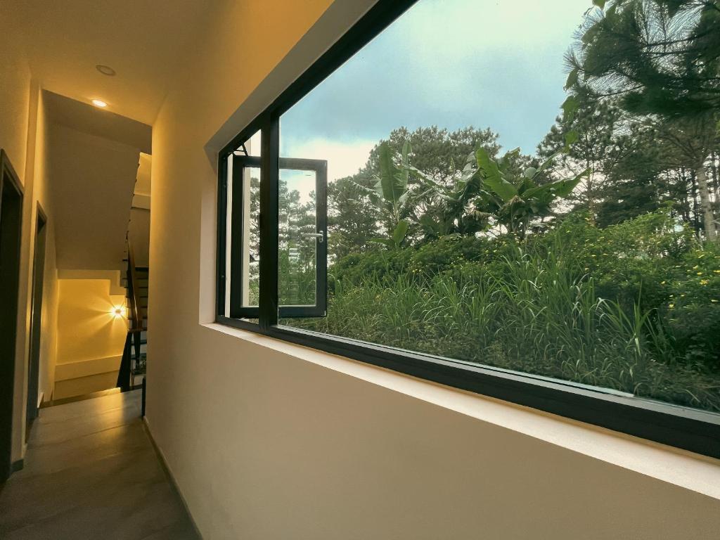 a window in a hallway looking out at a garden at Villa Délight House “Stay&Chill” in Da Lat