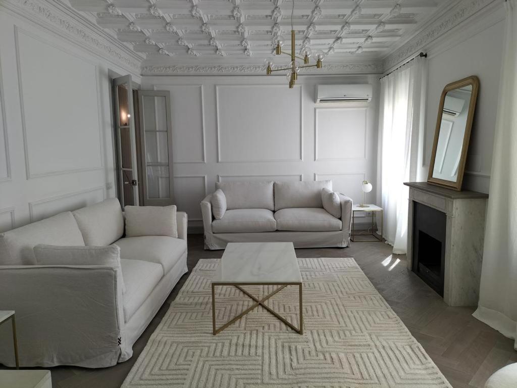 una sala de estar con 2 sofás blancos y una mesa. en Stunning Luxury Apartment, 2 min walk from Soho House, en Barcelona