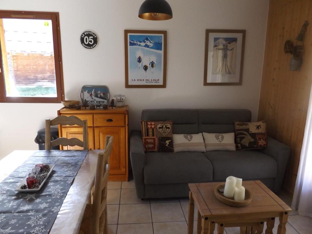 sala de estar con sofá y mesa en Chalet Bastilor, en La Joue du Loup