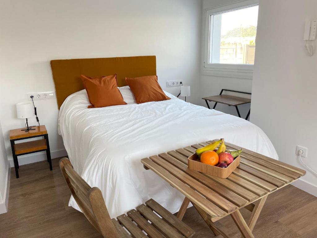 Bett mit Tisch und Obstschale darauf in der Unterkunft Casa acogedora mar y montaña in Pontevedra