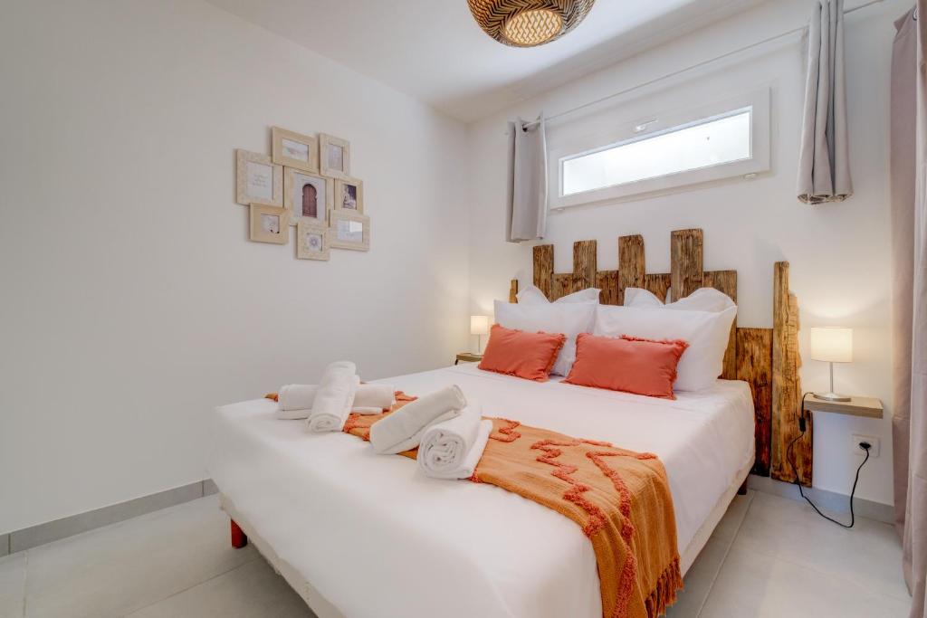 um quarto com uma grande cama branca com almofadas vermelhas em REVES DE PAMPA L Atelier em Lorgues