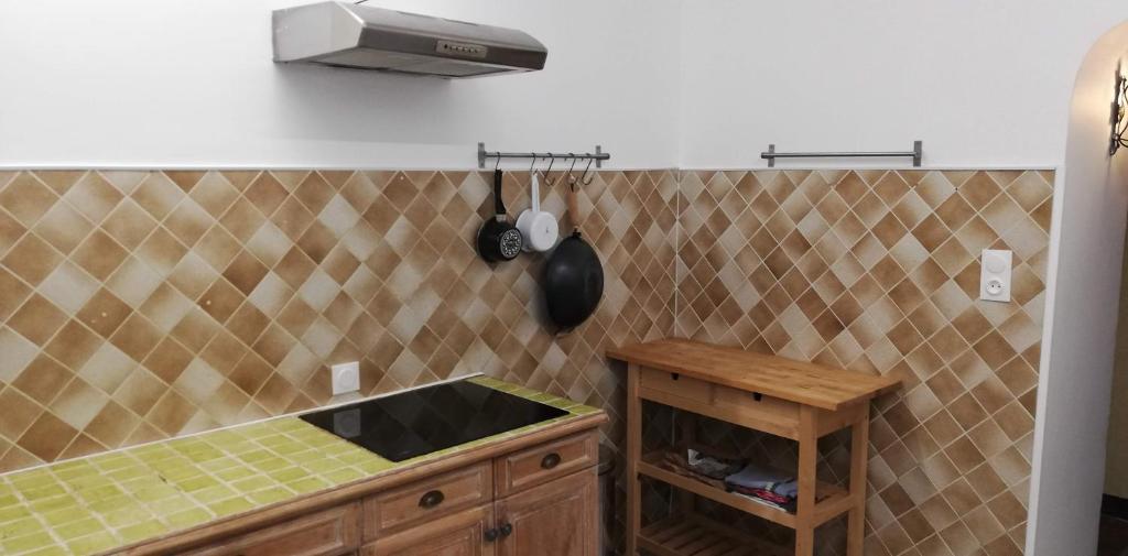 kuchnia ze zlewem i ścianą wyłożoną kafelkami w obiekcie Maison familiale Jardin parking, 10 min plage, 1* w mieście Saint-Cyr-sur-Mer
