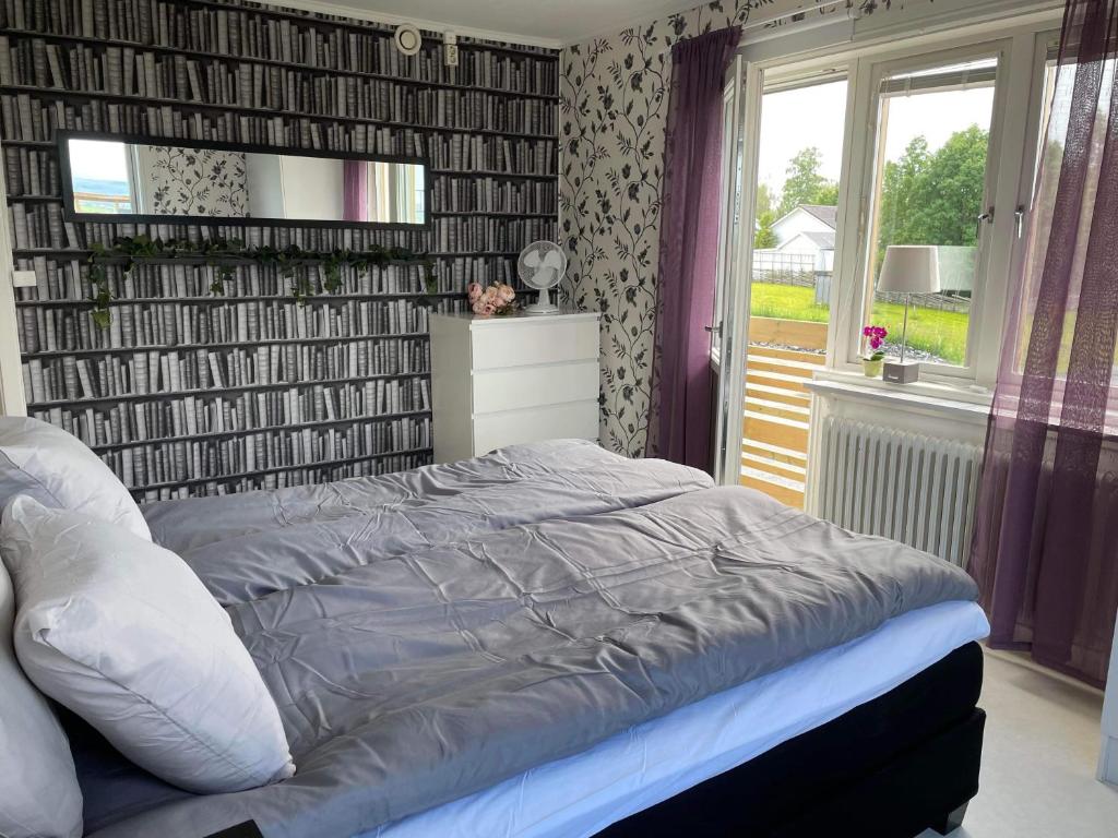 a bedroom with a bed with a mirror and a window at Fin lägenhet i centrala Oviken, mellan fjäll&stad in Oviken