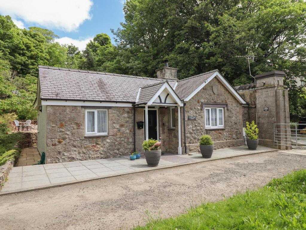 a small stone house with a porch at Glan Y Mor Lodge in Y Felinheli